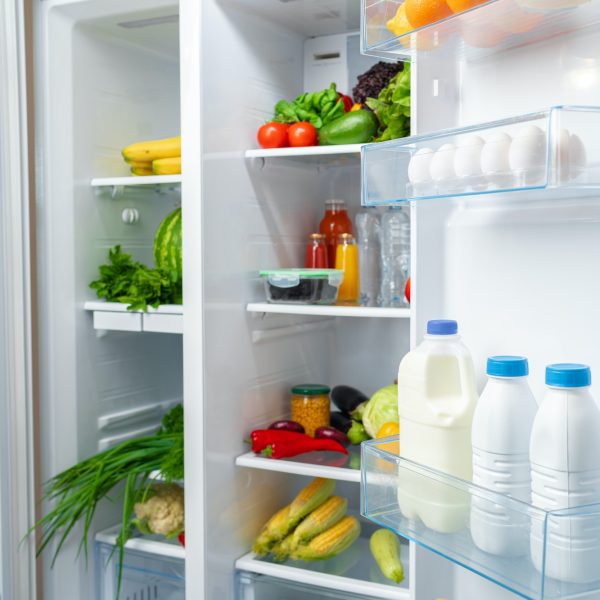 Open fridge full of fruits, vegetables and drinks